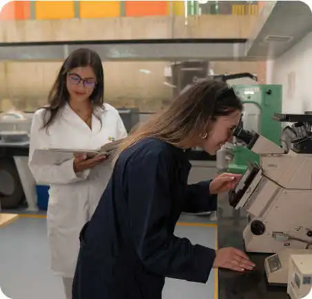 Estudiantes de Ingeniería Industrial de la Universidad de América trabajando en laboratorio con microscopio y registro académico