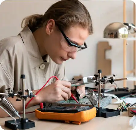 Estudiante de Ingeniería Mecatrónica trabajando en laboratorio con dispositivos electrónicos