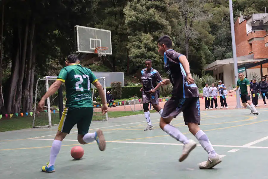 Estudiantes de la Universidad de América jugando fútbol en las actividades deportivas del Bienestar Institucional.