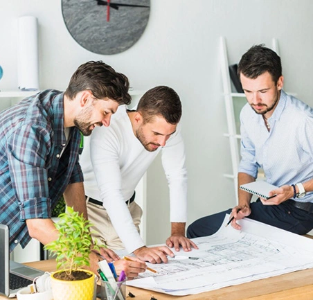 Equipo de trabajo analizando planos en la Especialización en Gerencia de Proyectos de la Universidad de América