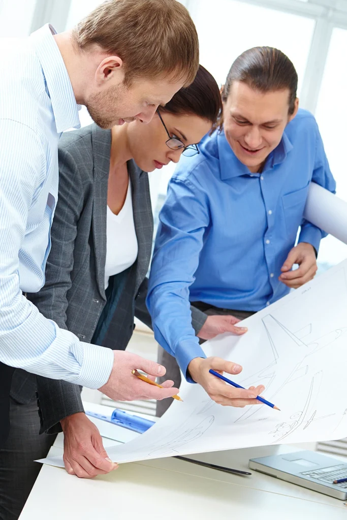 Profesionales revisando planos estratégicos en la Especialización en Gerencia de Proyectos de la Universidad de América