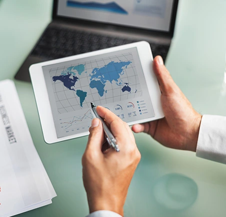 Profesional revisando mapa global en dispositivo digital en la Especialización en Negocios Internacionales e Integración Económica de la Universidad de América