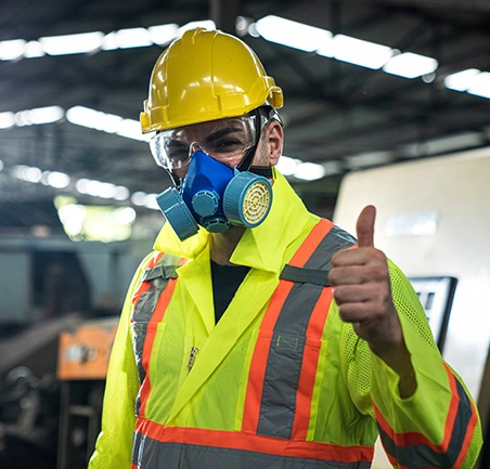 Trabajador con casco y mascarilla como símbolo de prevención de riesgos laborales en la Especialización en Gestión de la Seguridad y Salud en el Trabajo de la Universidad de América