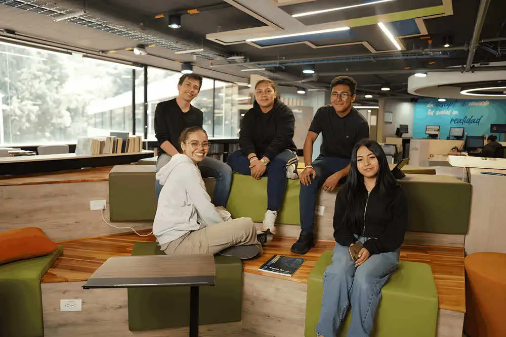 Grupo de estudiantes de la Universidad de América en un espacio colaborativo moderno.