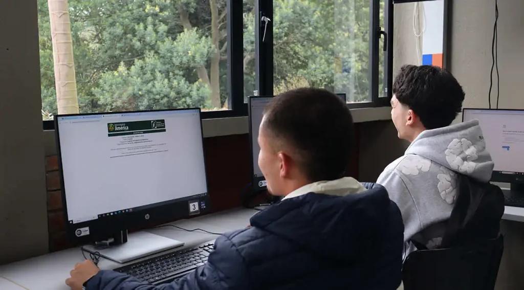 Estudiantes realizando registro académico en sala de cómputo de la Universidad de América