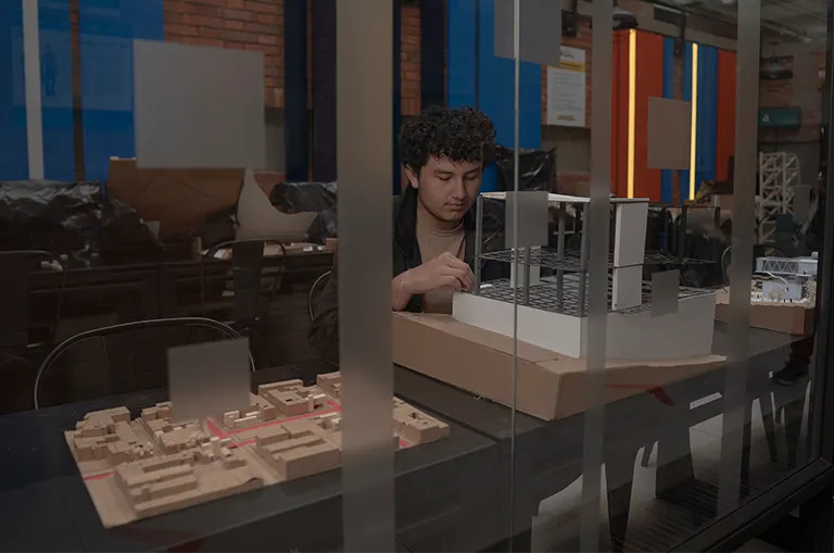 Estudiante de Arquitectura de la Universidad de América elabora una maqueta en un laboratorio especializado como parte de su formación práctica en diseño arquitectónico. estudiar Arquitectura en Bogotá