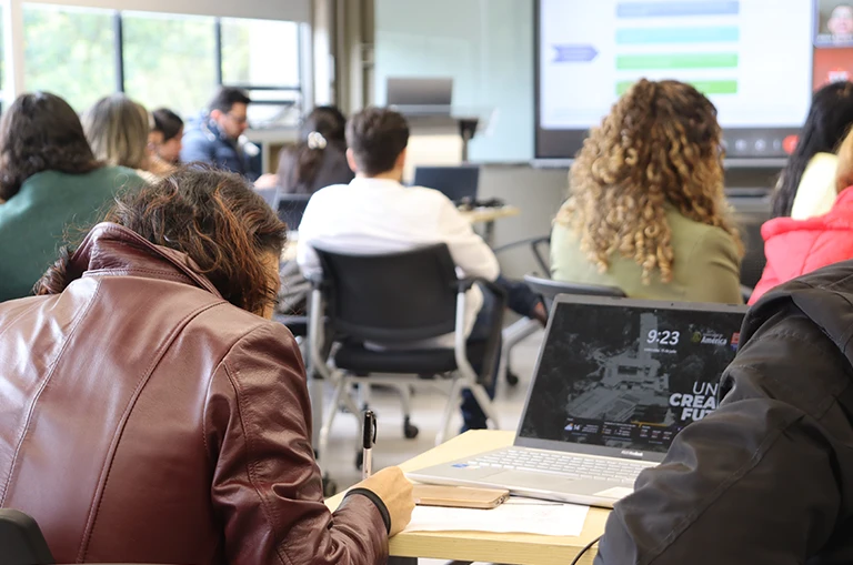 Participante toma apuntes durante las jornadas de Sensibilización I+D+i de la Universidad de América.